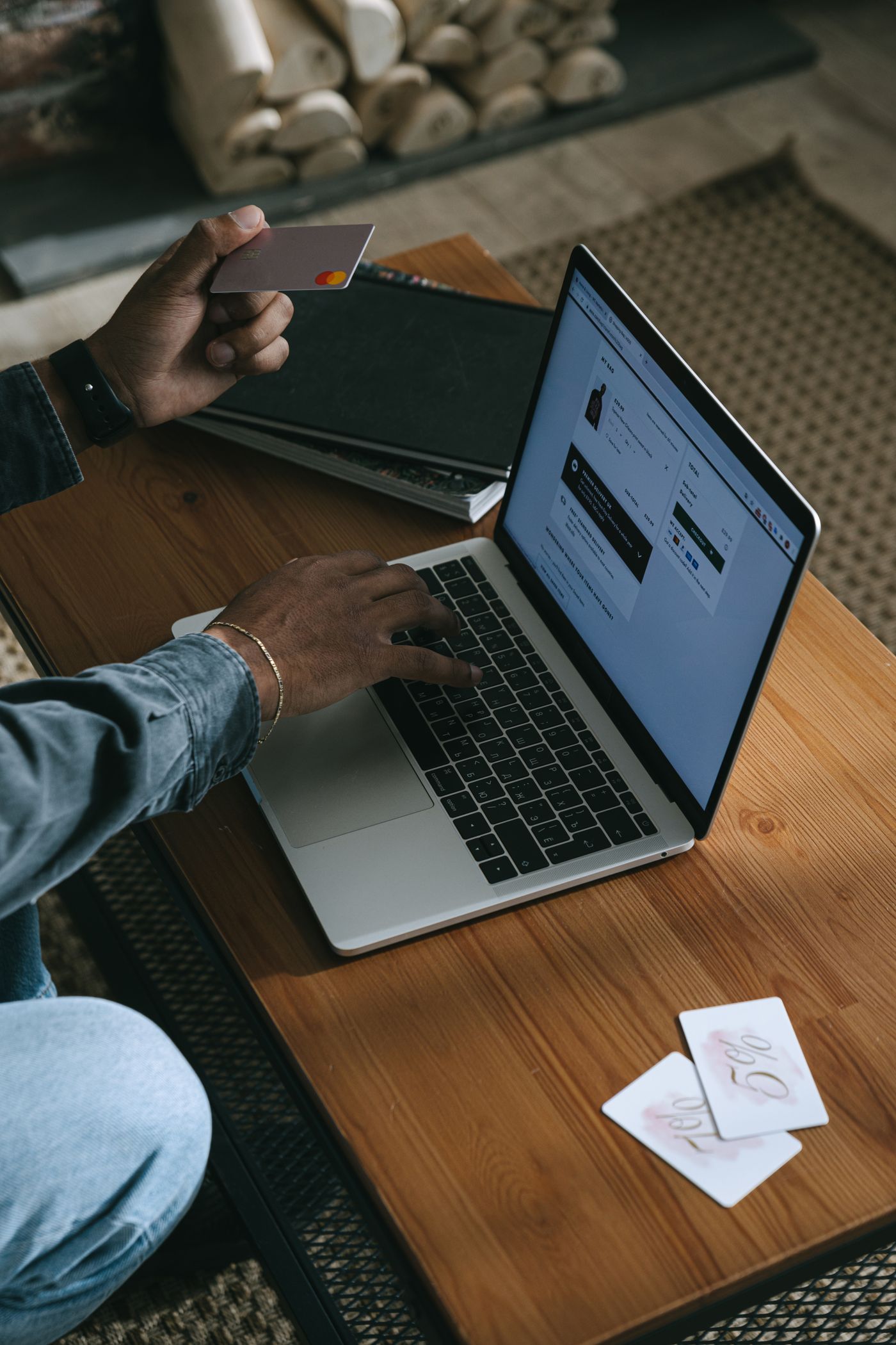 A person shopping online with a laptop and payment card