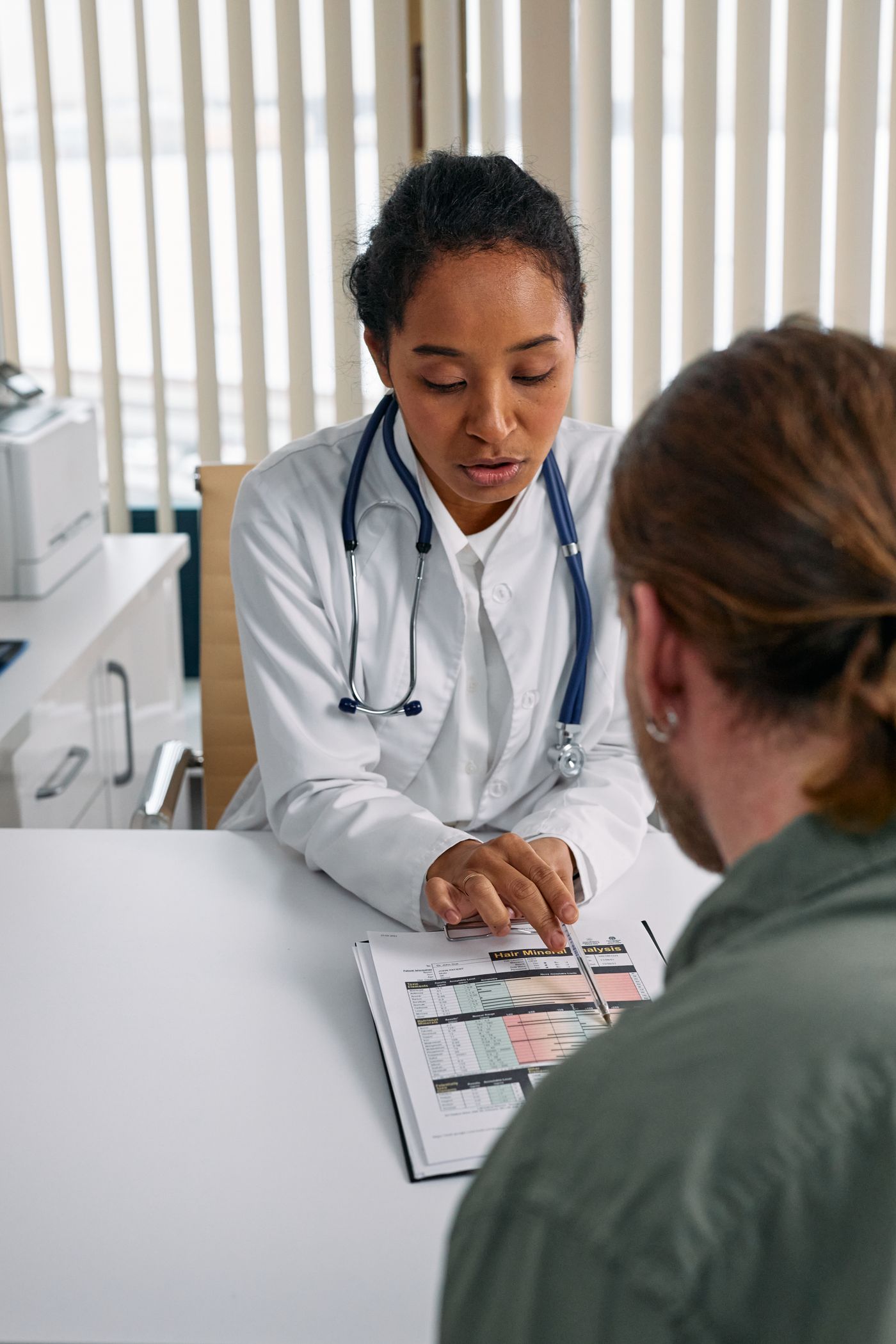 A doctor discussing a chart with a patient at a desk